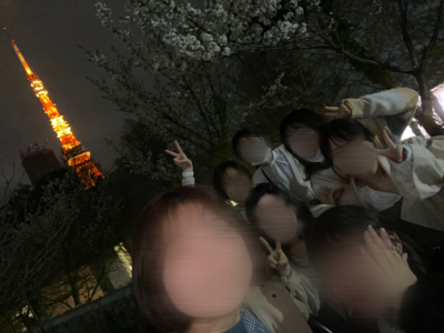 寮の友達と東京タワーを背景に写真を撮る様子