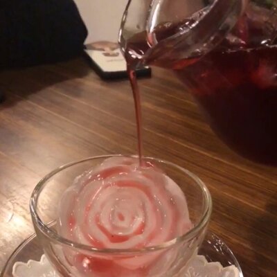 氷の花にジュースを注いでいる写真